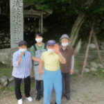 屋外で複数の入居者が集合して立っている風景。庭園内での交流や散歩の様子。